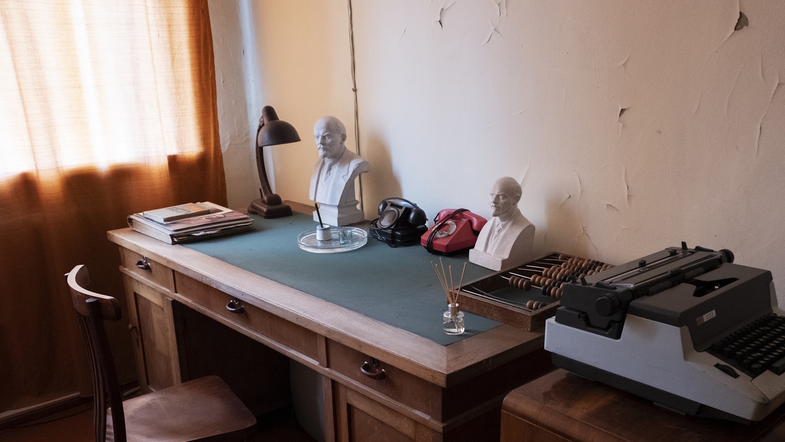 a desk with a computer and statues on it